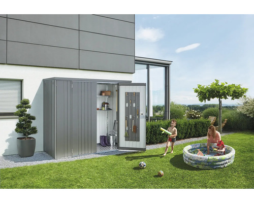 Záhradná scéna s kôlňou na náradie pri dome, vrátane záhradného náradia a hrajúcich sa detí v bazéne.