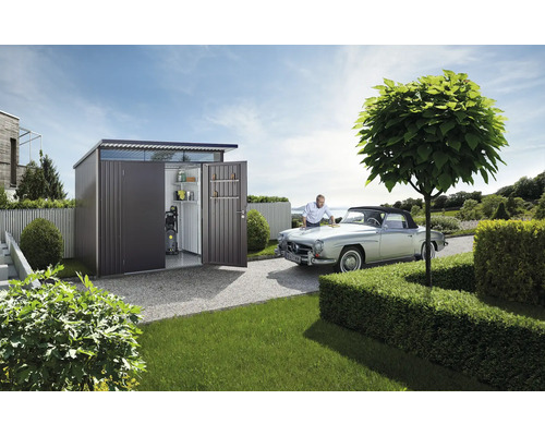 Záhradná scéna s kôlňou na náradie, veteránom a osobou, ktorá sa stará o auto