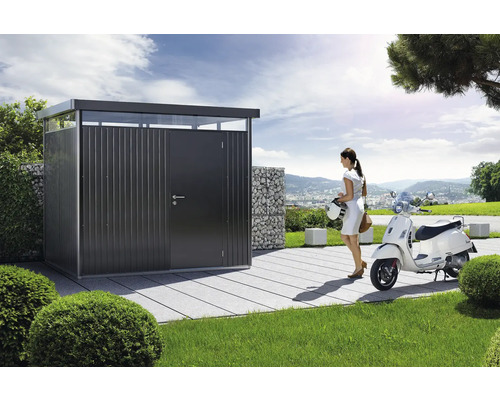 Záhradný domček so ženou a skútrom v záhrade