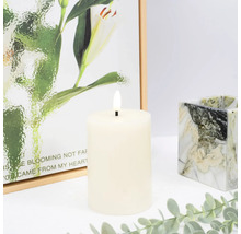 Dekoratívna LED stĺpová sviečka s maľbou v pozadí a mramorovaným svietnikom.