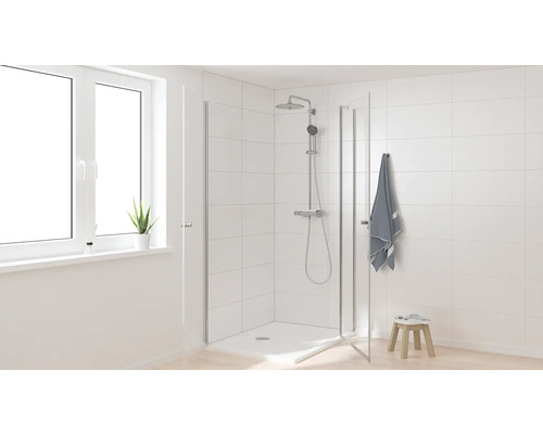 Svetlá kúpeľňa so sprchou, sprchovou hlavicou, uterákom a oknom pre priateľské prostredie.