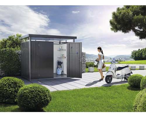 Moderná kovová skriňa na náradie s policami, tlakovou umývačkou a ženou so skútrom v záhrade.