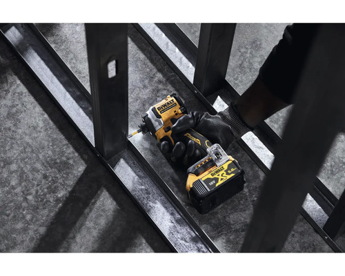 Logo spoločnosti DeWalt. Osoba skrutkuje kovový profil pomocou akumulátorového rázového uťahovača.