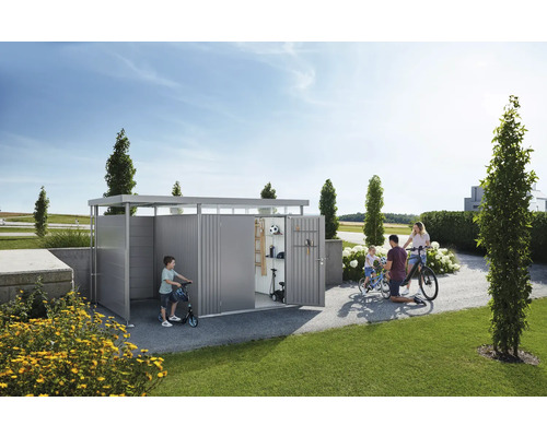 Rodina s bicyklami a kolobežkami pred záhradným domčekom v záhrade.