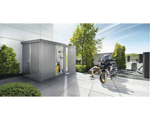 Kovová záhradná chatka s otvorenými dverami a motocyklom na terase