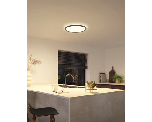 Moderná kuchyňa s okrúhlym stropným svietidlom, ktoré vytvára svetlú a príjemnú atmosféru.