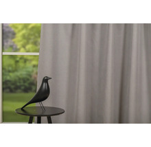 Dekorácia s vtákom na stole pred oknom so závesom