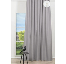 Pohľad na sivý záves pred oknom s ozdobnou figúrkou na stole