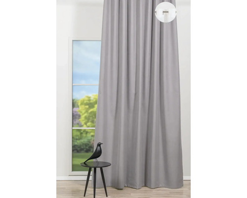 Pohľad na sivý záves pred oknom s ozdobnou figúrkou na stole