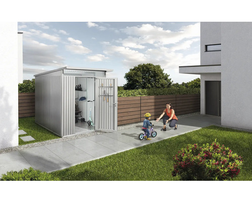 Kovový záhradný domček s otvorenými dverami a hrajúcim sa dieťaťom v záhrade