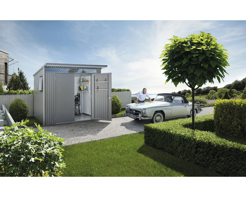 Kovová kôlňa s otvorenými dverami, policami a tlakovou umývačkou, osoba leští auto