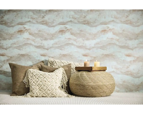 Obývacia izba so vzorovanou tapetou, ozdobnými vankúšmi a sedacím pufom