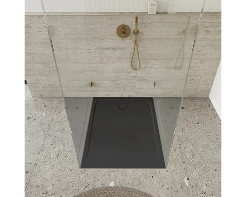 Sprchovací kút v úrovni podlahy so sivou sprchovou vaničkou a sprchovou hlavicou