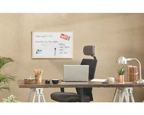 Písací stôl s tabuľou, kancelárskymi potrebami a notebookom pre organizáciu kancelárie