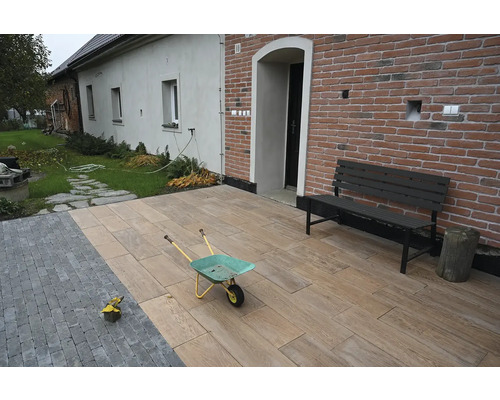 Exteriér s dlažbou so vzhľadom dreva, kolieskom a lavičkou