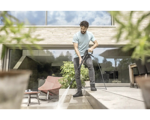 Muž čistí terasu vysokotlakovým čističom