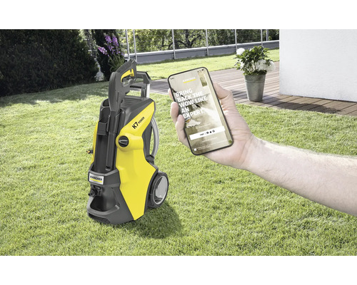 Žltý vysokotlakový čistič Kärcher K7 Power s aplikáciou pre smartfón na trávniku