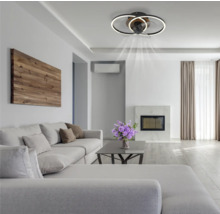 Obývacia izba so stropným ventilátorom s osvetlením, pohovkou a krbom vytvára svetlú a priestrannú atmosféru.