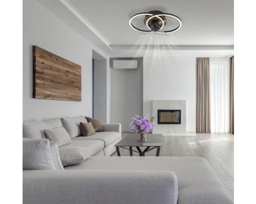 Obývacia izba so stropným ventilátorom s osvetlením, pohovkou a krbom vytvára svetlú a priestrannú atmosféru.