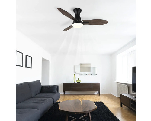 Obývacia izba so stropným ventilátorom s osvetlením, pohovkou, stolom a komodou