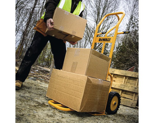 Žltý rudel naložený kartónmi, obsluhovaný osobou s bezpečnostnou vestou