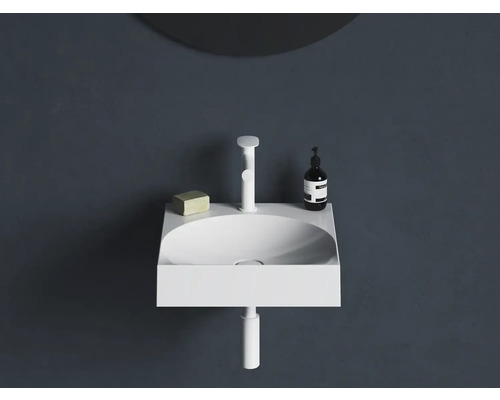 Moderné umývadlo s batériou, mydlom a dávkovačom na tmavej stene