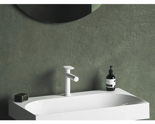 Umývadlo s batériou, mydlom a dávkovačom pred stenou so zrkadlom