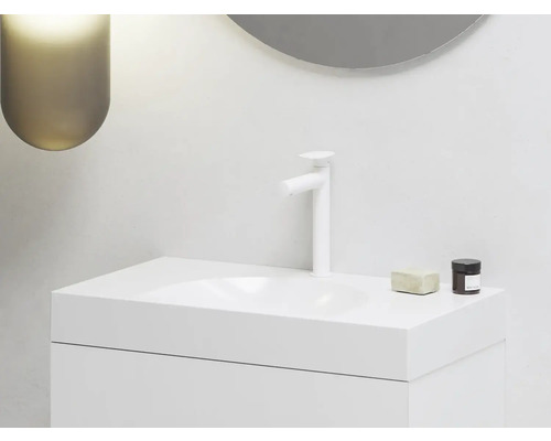 Moderná kúpeľňa s bielym umývadlom, batériou, mydlom a kozmetickou dózou