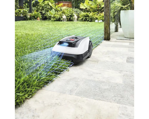 Robotická kosačka na trávniku a kamenných doskách v záhrade
