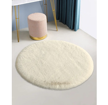 Biely okrúhly koberec so stoličkou a stolom v pozadí