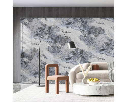 Obývacia izba s mramorovou stenou, pohovkou, kreslom, stojacou lampou a konferenčným stolíkom