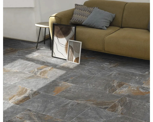 Obývacia izba s podlahovými dlaždicami so vzhľadom kameňa, pohovkou a dekoráciou