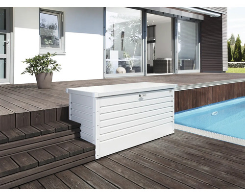 Snímka bieleho kovového boxu na náradie na drevenej terase vonku.