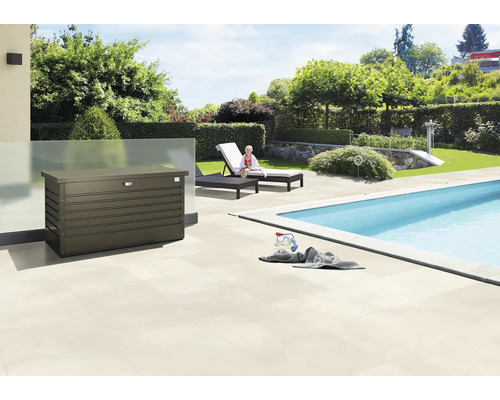 Vonkajšia scéna s úložným boxom vedľa bazéna, ležadlami a záhradou.