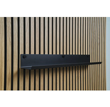 Čierna nástenná polica na drevenej stene