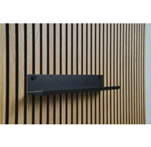 Čierna nástenná polica na drevenej obkladovej stene