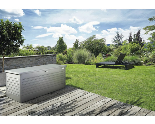 Záhradná krajina s kovovým úložným boxom a lehátkom na trávniku