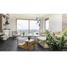 Obývacia izba s pohovkou, kreslom, stolom a drevenou truhlou na tmavej podlahe