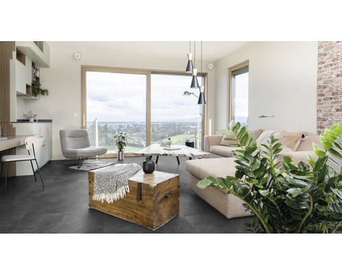 Obývacia izba s pohovkou, kreslom, stolom a drevenou truhlou na tmavej podlahe