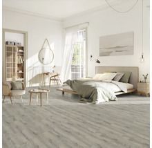 Svetlá spálňa s posteľou, stoličkou, stolom a laminátovou podlahou s dreveným vzhľadom.