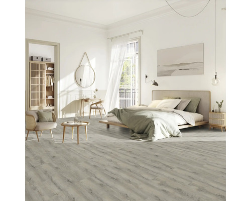 Svetlá spálňa s posteľou, stoličkou, stolom a laminátovou podlahou s dreveným vzhľadom.