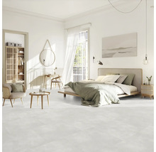 Svetlá spálňa s posteľou, sedením, skriňou a dekoráciami na svetlej podlahe