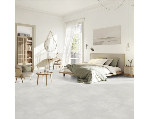 Svetlá spálňa s posteľou, sedením, skriňou a dekoráciami na svetlej podlahe