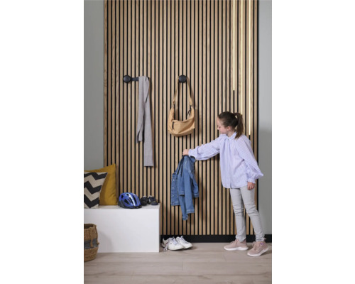 Chodba s drevenou lamelovou stenou, háčikmi na šaty a dieťa