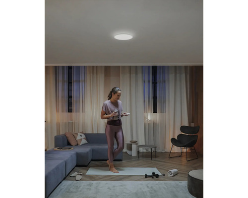 Žena športuje v obývacej izbe so stropným svetlom