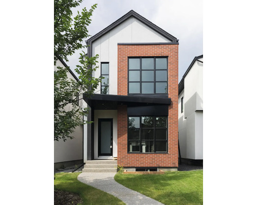 Pohľad na moderný dvojpodlažný dom s fasádou z tehál a omietky