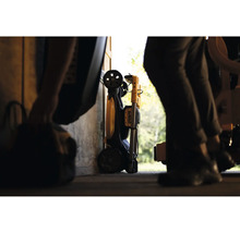 Zložený pracovný svetlomet DeWalt s transportnými kolieskami, uložený v dielni