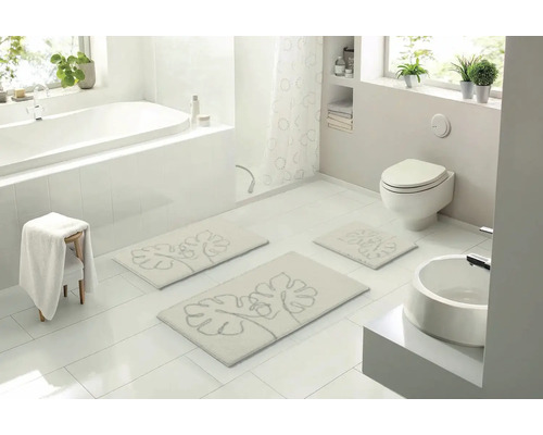 Svetlá kúpeľňa s vaňou, toaletou, umývadlom a súpravou kúpeľňových predložiek s rastlinným motívom