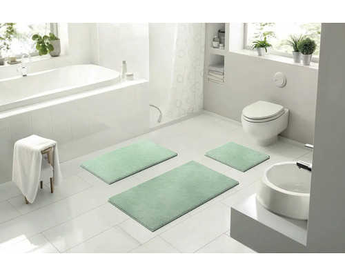 Moderná kúpeľňa s vaňou, toaletou, umývadlom a súpravou 3-dielnych kúpeľňových predložiek.