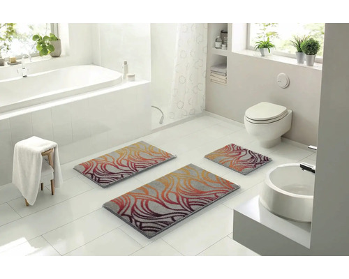 Svetlá kúpeľňa s vaňou, toaletou, umývadlom a súpravou troch kúpeľňových predložiek so vzorom